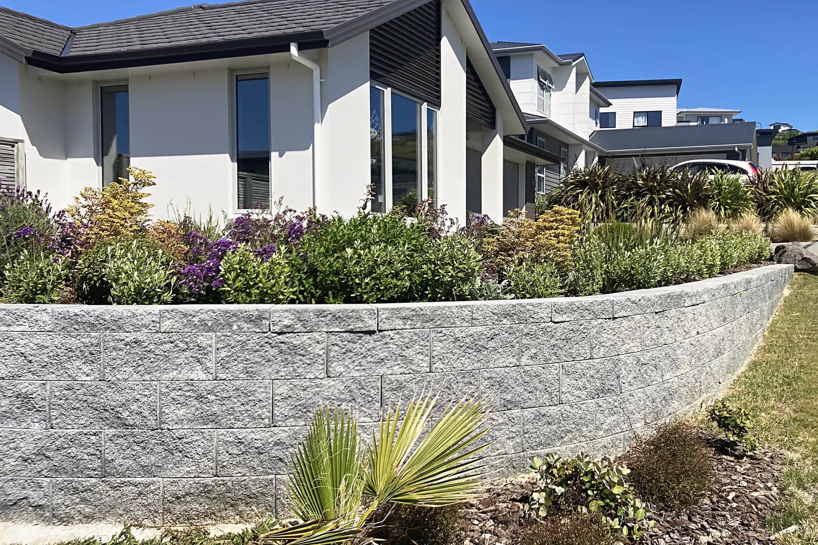 Curved block retaining wall with planting above, Aotea