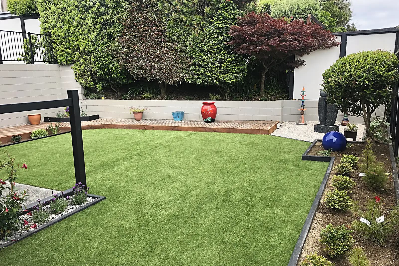 Lawn with garden beds and a timber deck edge, Camborne