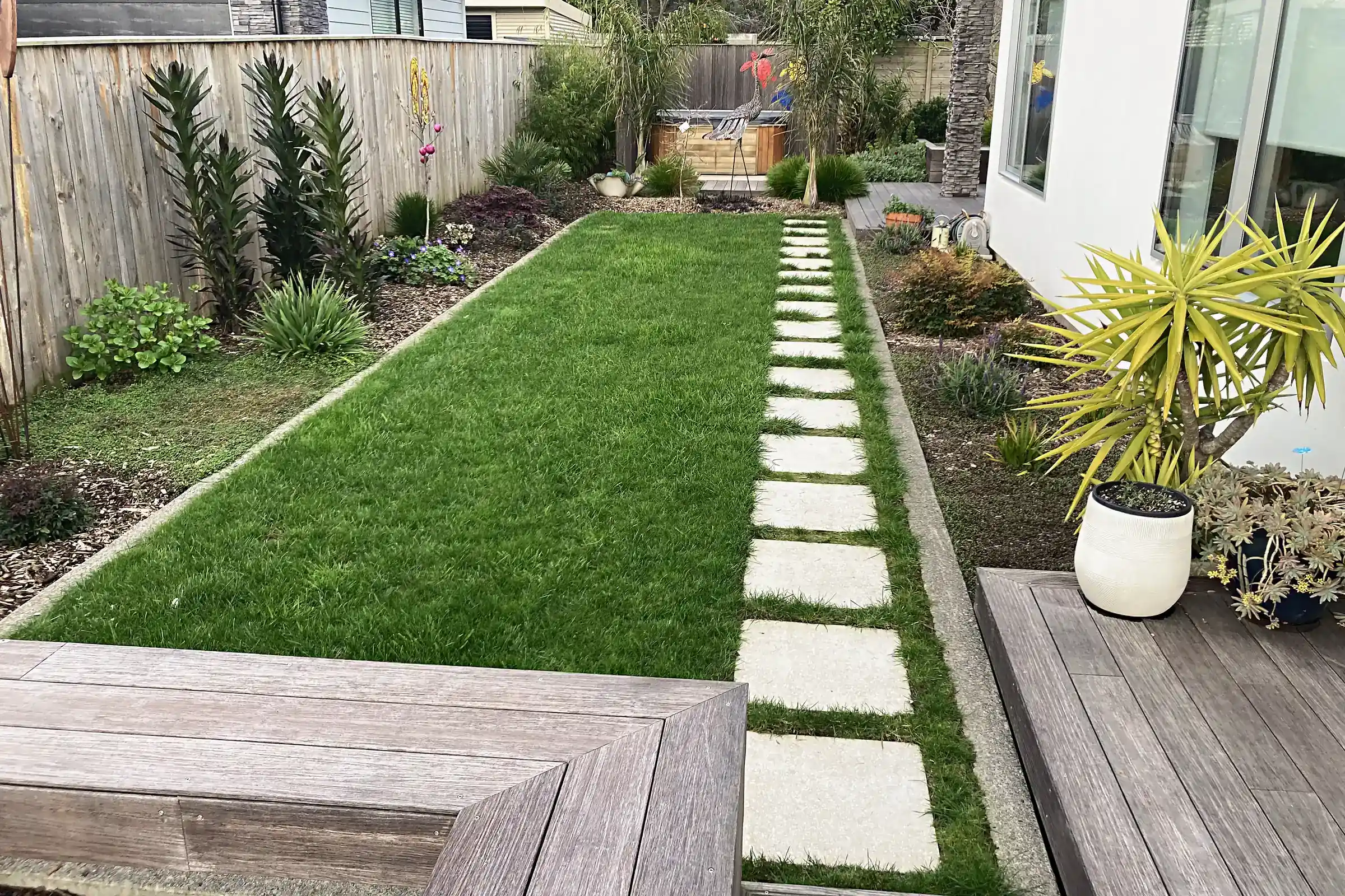 Lawn with a paver path beside a timber deck, Otaki