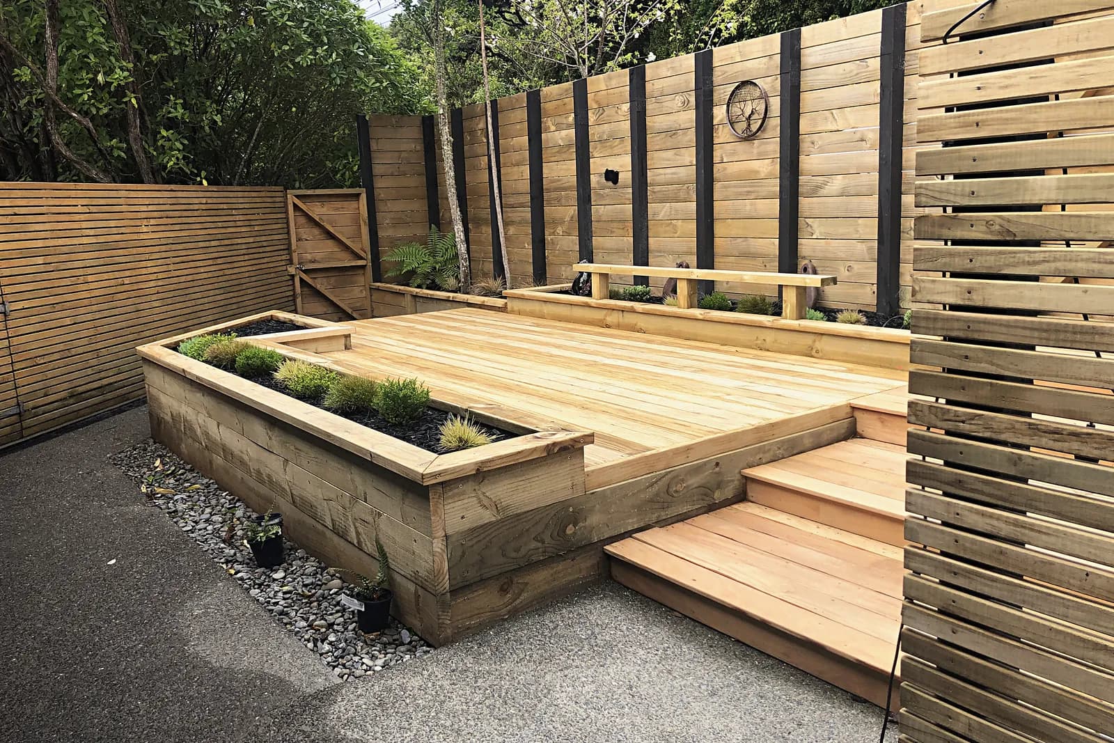 Timber deck with a built-in bench, raised planter and slat screens, Pukerua Bay