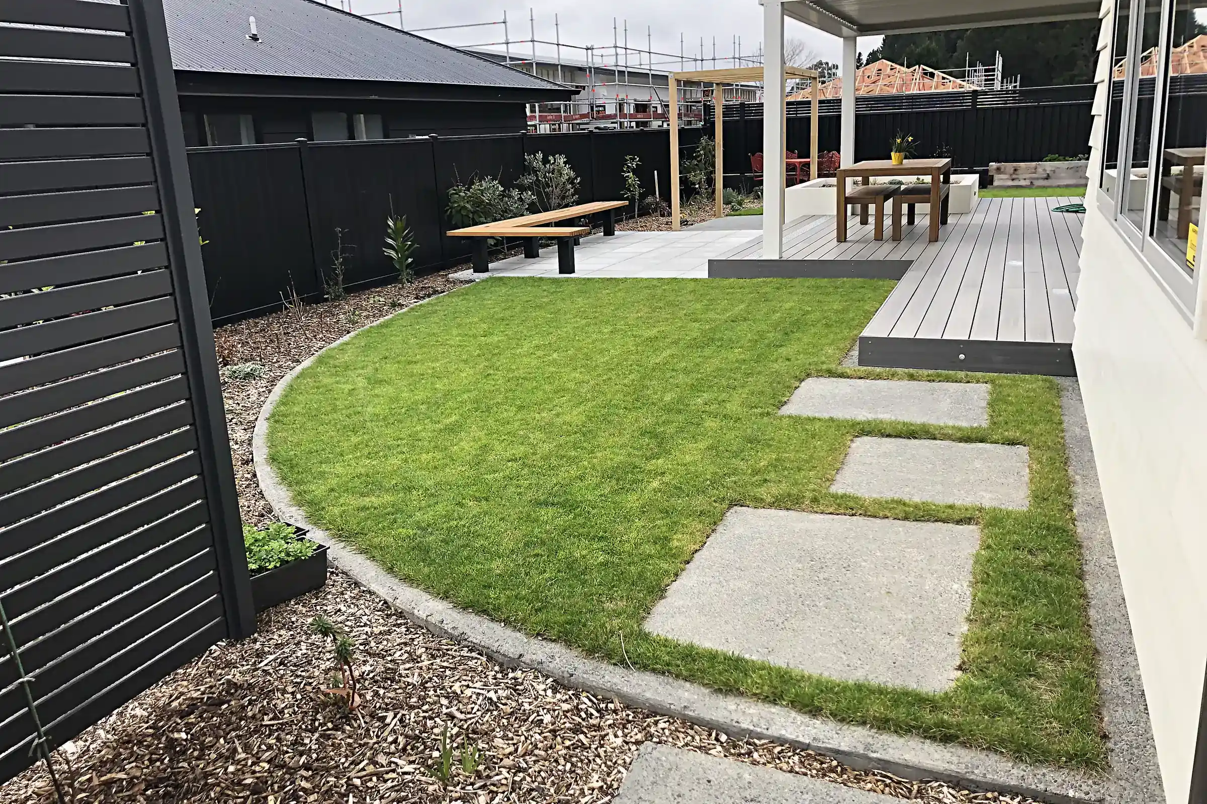 Curved lawn with stepping pavers beside a deck, Trentham