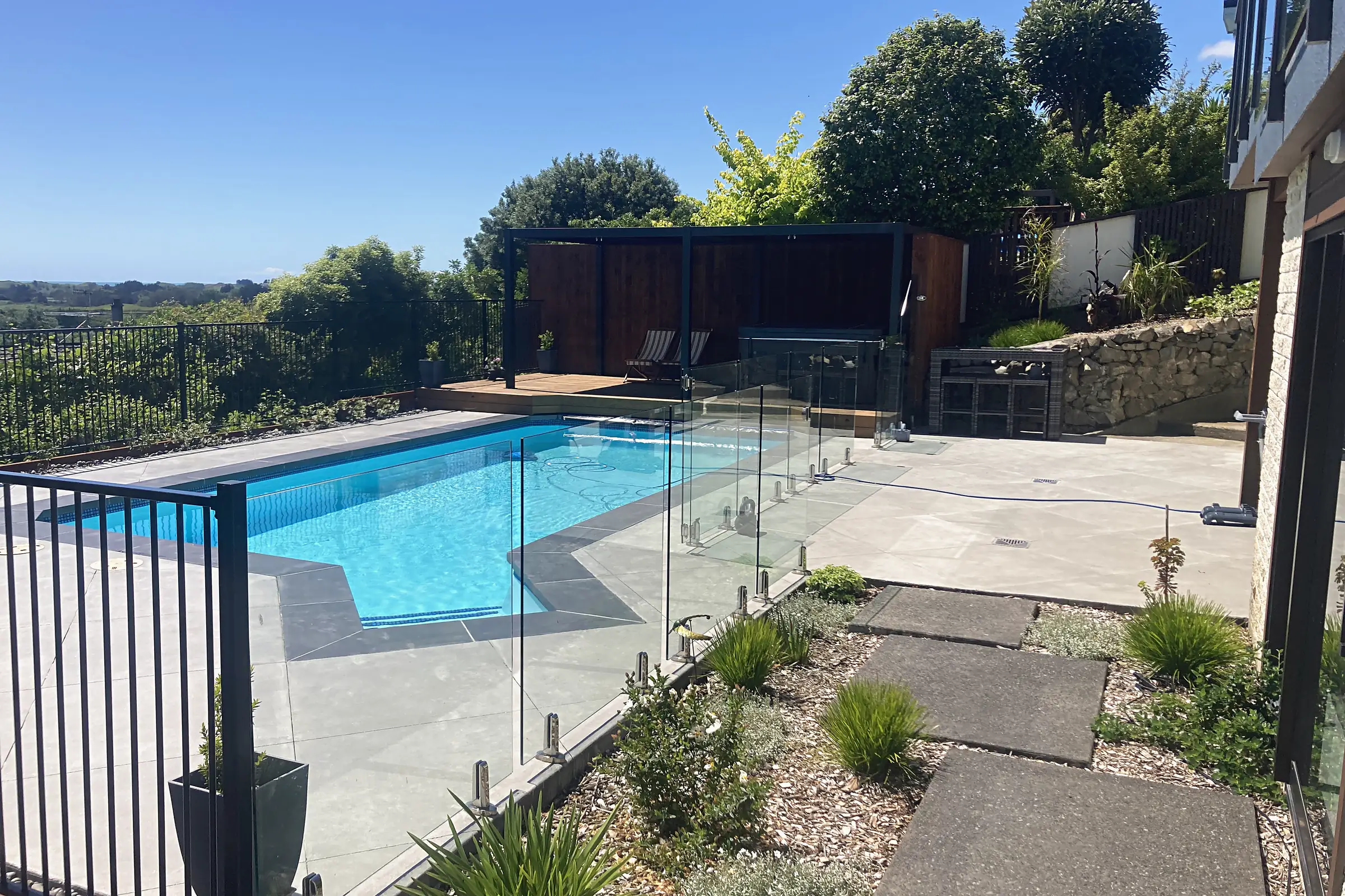 Pool with paving, glass fencing and stepping pavers, Waikanae