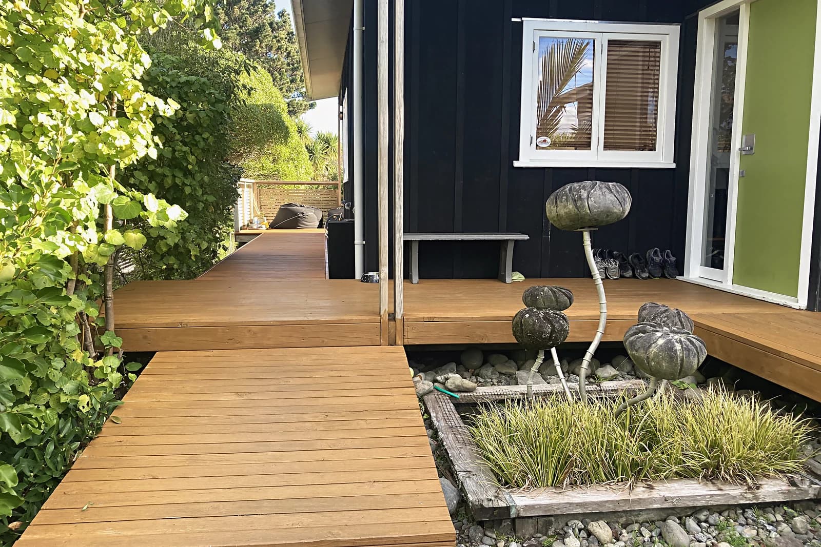 Timber deck and boardwalk beside a planted bed, Waikanae Beach
